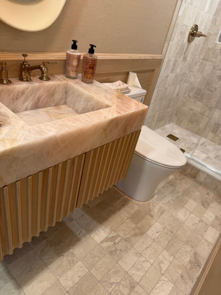 Detail angle of fluted oak vanity and brass faucets